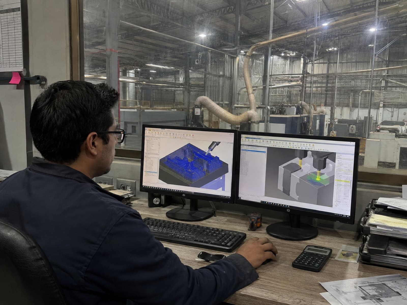 Engineer coordinating production from a dual-screen workstation